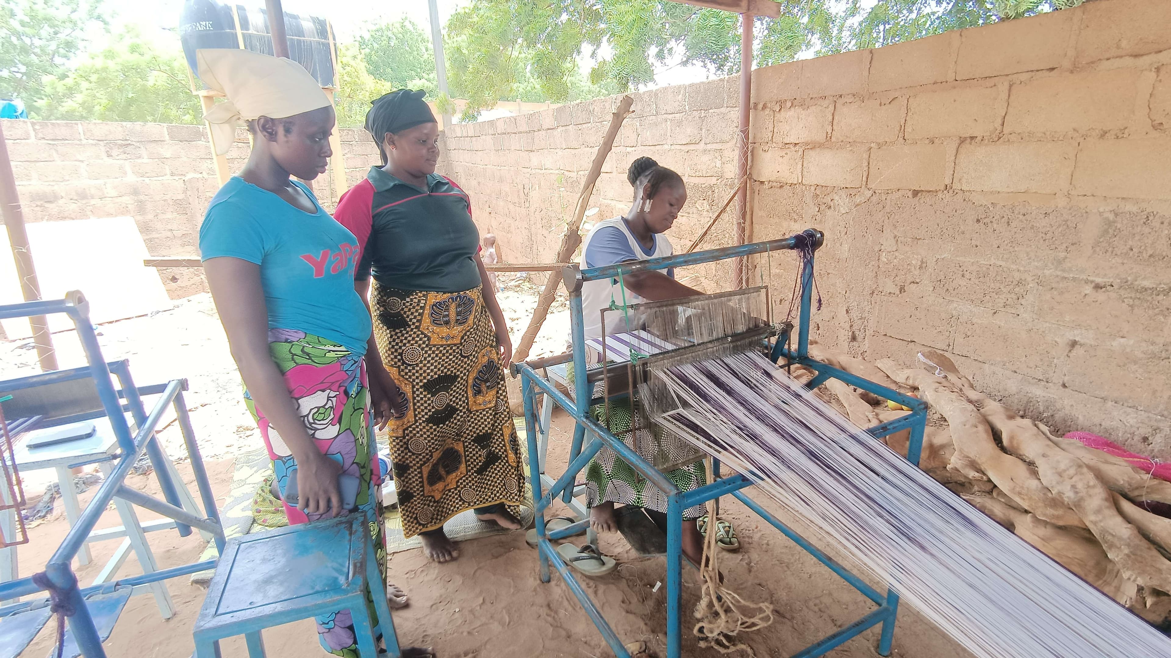 Three women learning to weave.