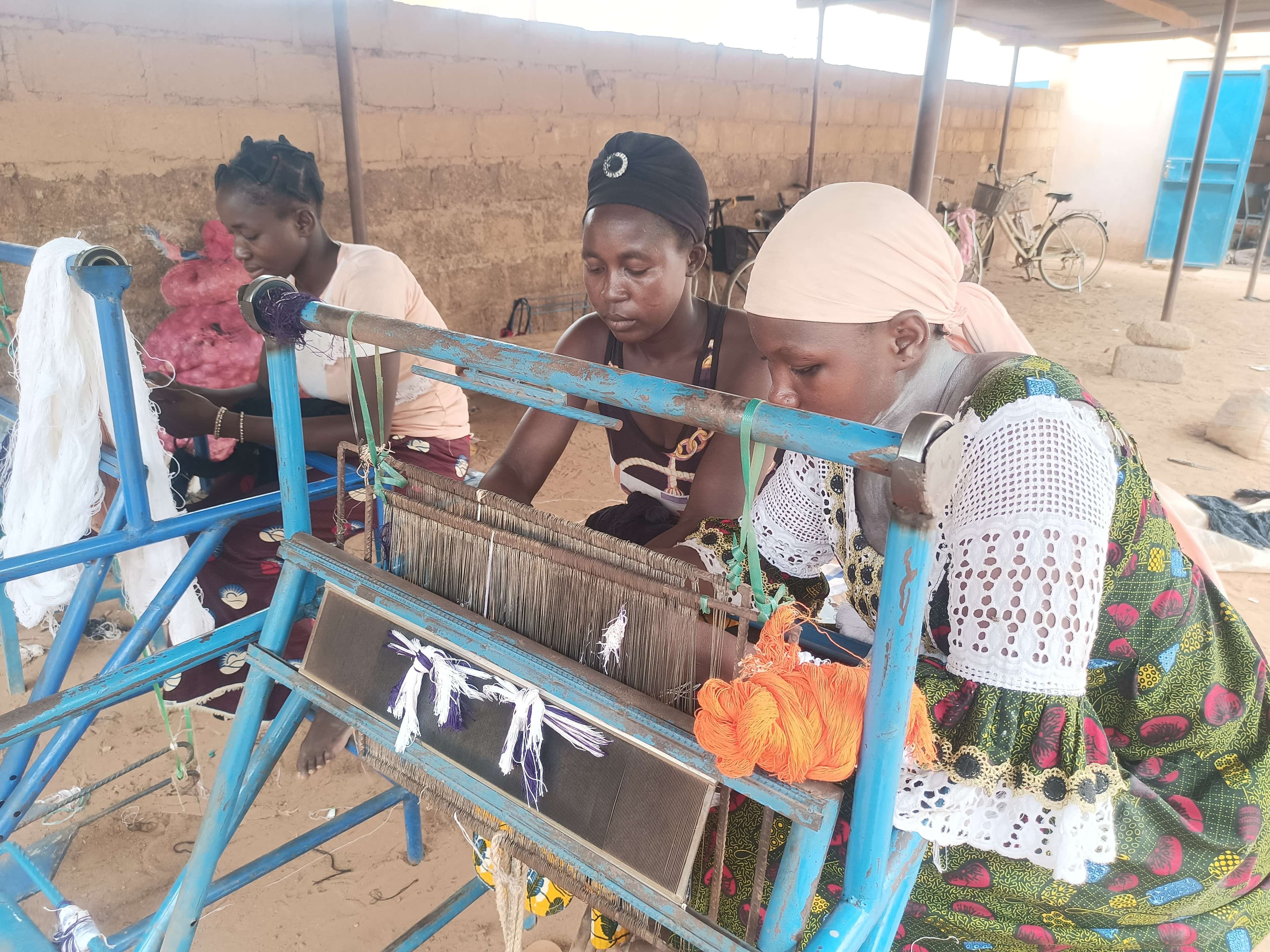 Women pass the threads through the comb