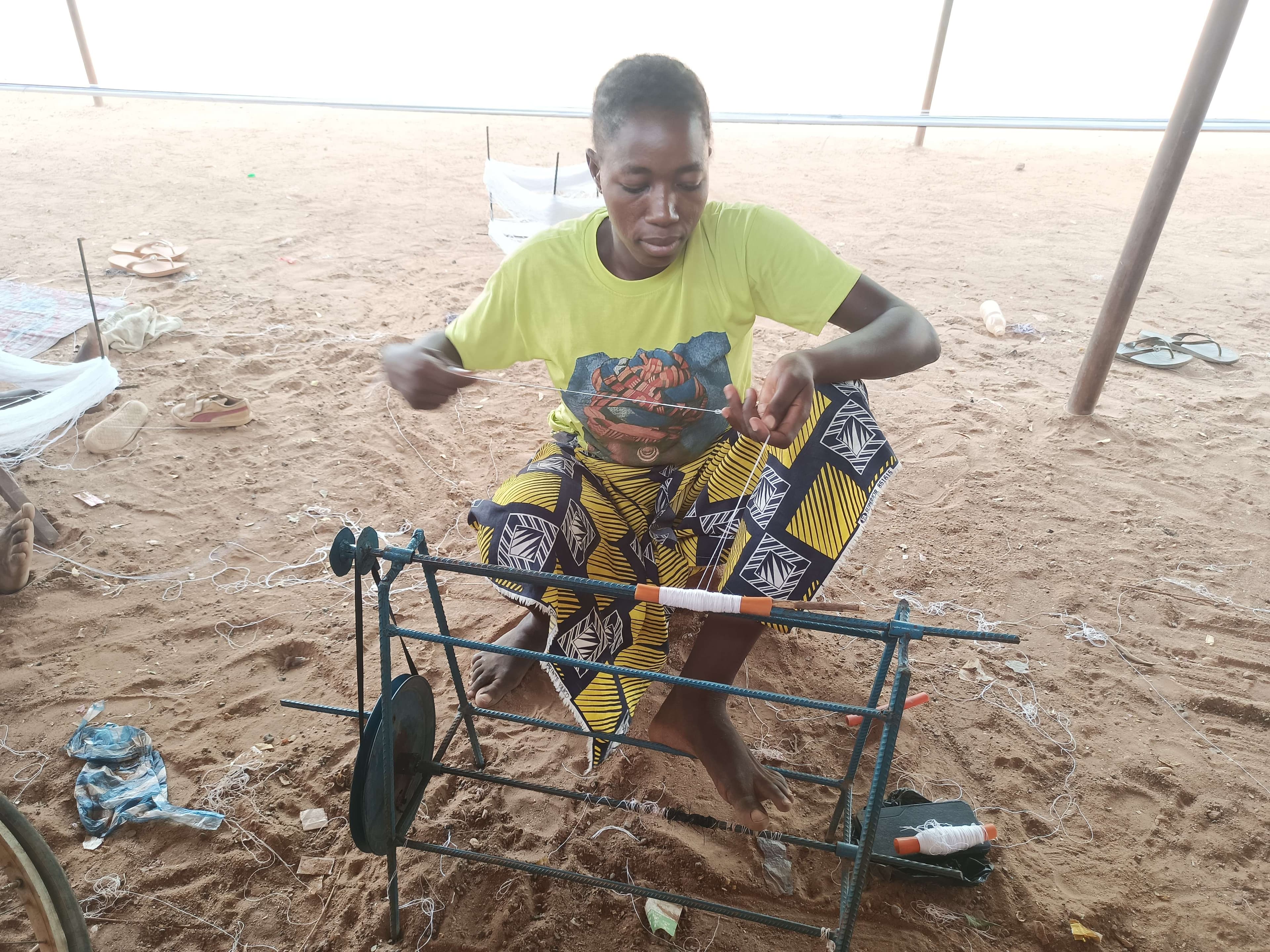 A woman rolling weaving thread.