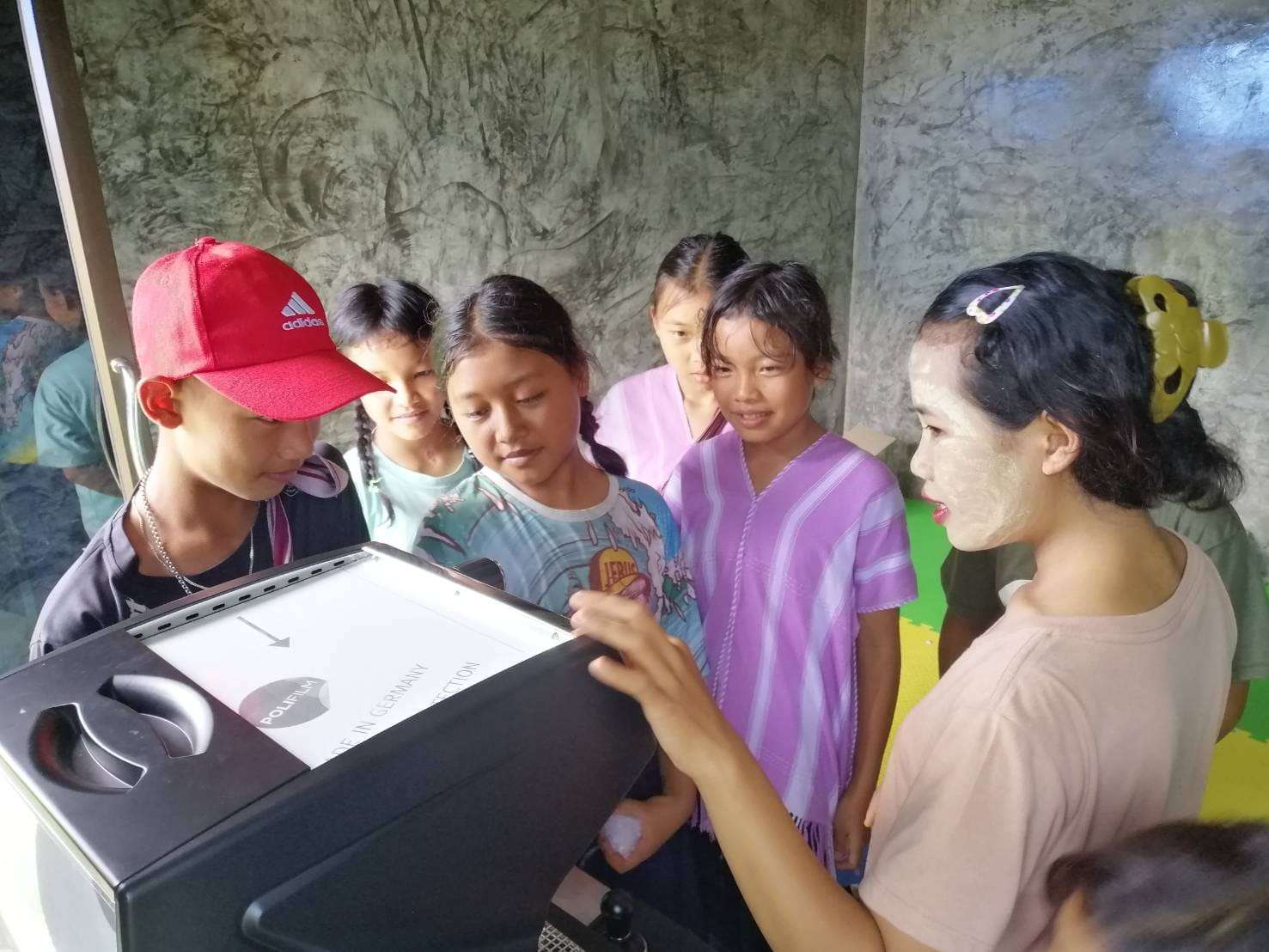 The youngsters are practicing how to use the coffee maker.